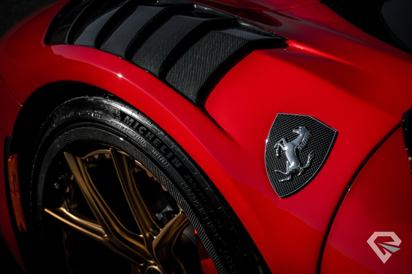 Close detail of a red Ferrari fender over bronze wheels