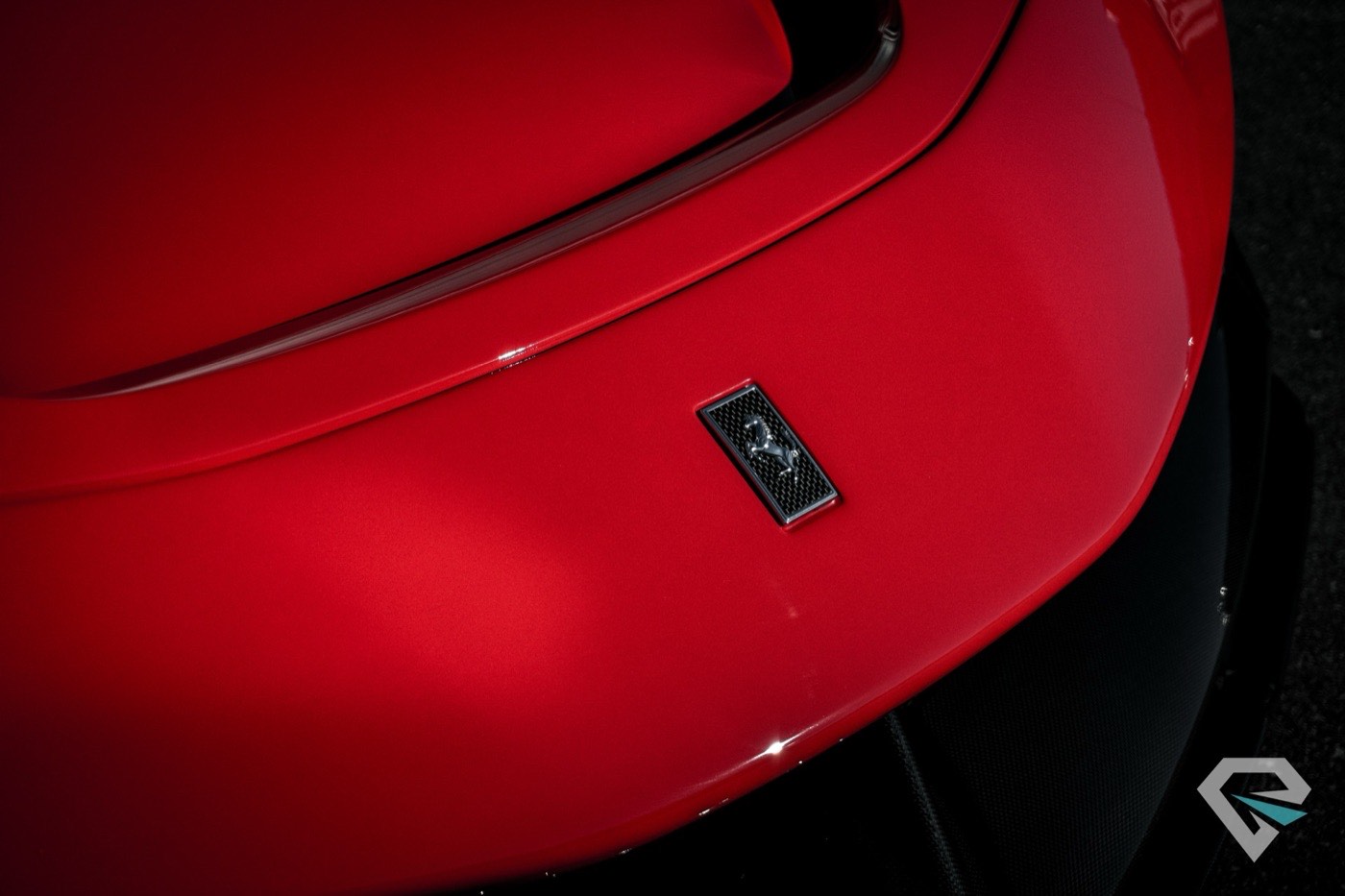 Close detail of the Ferrari badge on a red fender